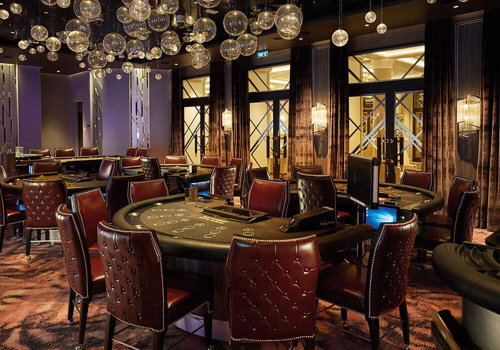 The Casino mit Pokertischen, Spielautomaten und eleganten Ledersessel auf Luxusschiff