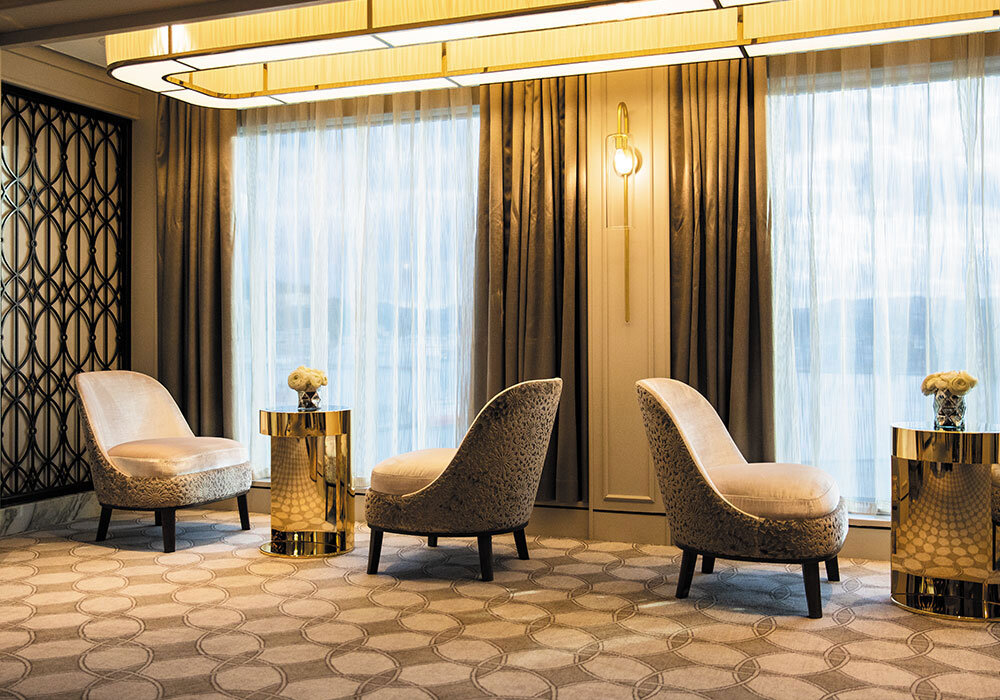 Observation Lounge mit Sesseln, Fensterplätzen und modernem Interieur auf Luxusschiff