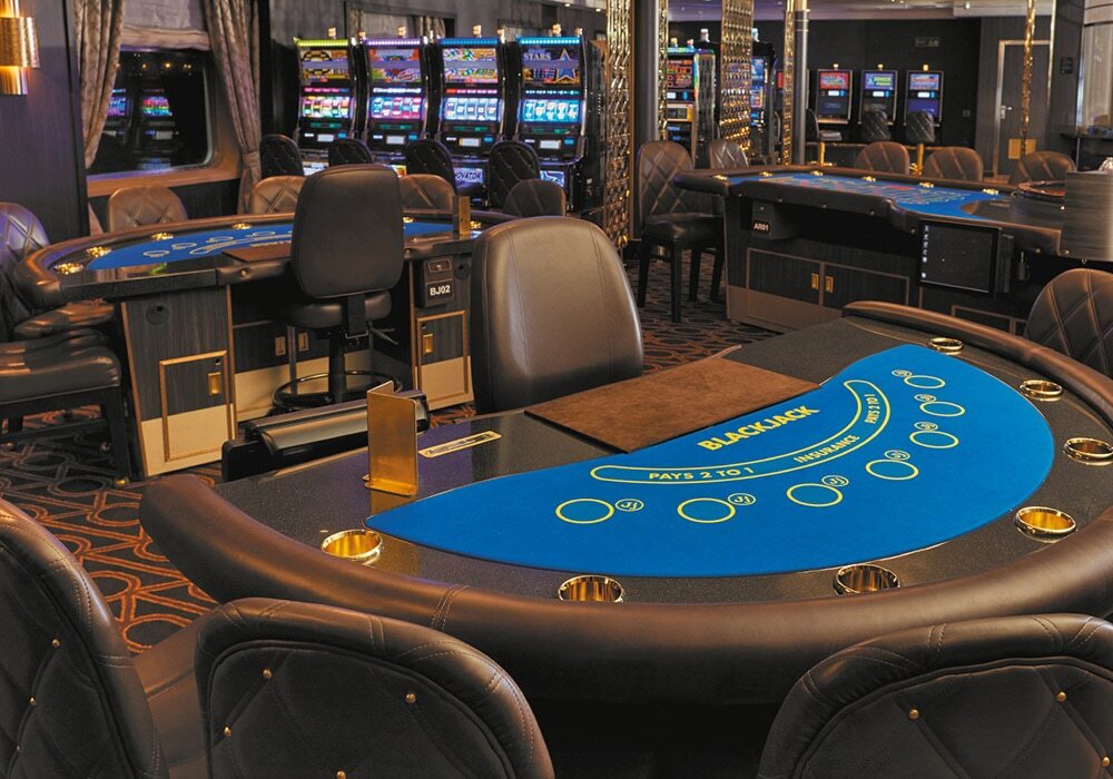 Casino mit Spieltischen, Spielautomaten und modernem Interieur auf Luxusschiff