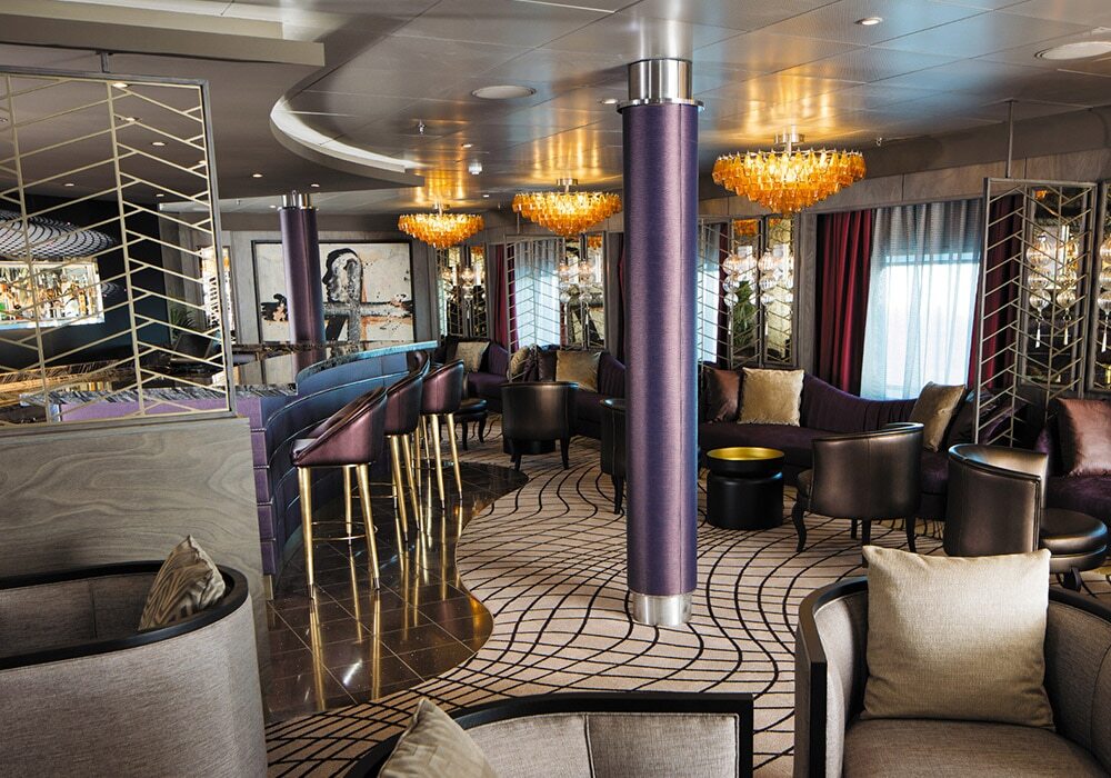 Voyager Lounge mit Sesseln, Deckenleuchten und modernem Interieur auf Luxusschiff