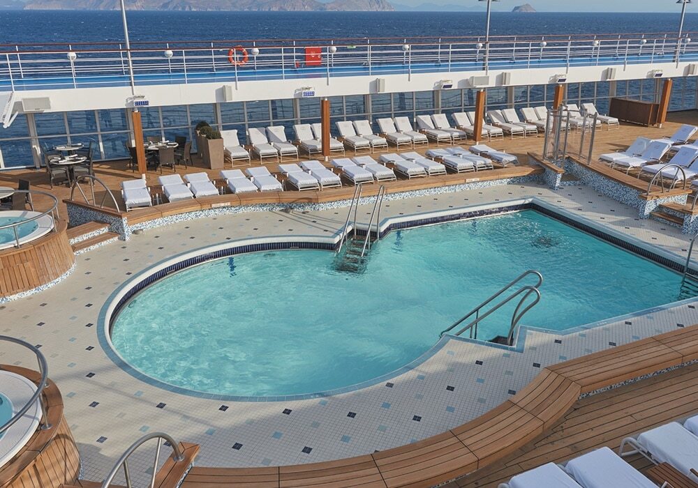 Pool Deck mit Liegestühlen und Meerblick auf Hochsee-Kreuzfahrtschiff