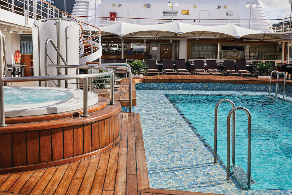 Pooldeck der Silver Wind Expedition mit rechteckigem Außenpool, rundem Whirlpool, Teakdeck und Liegestühlen