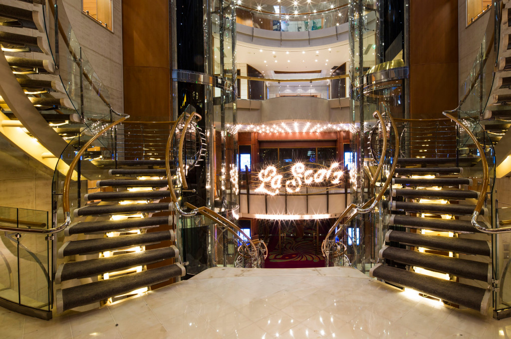 Lobby mit eleganter Treppe und Beleuchtung auf der Voyager of the Seas.