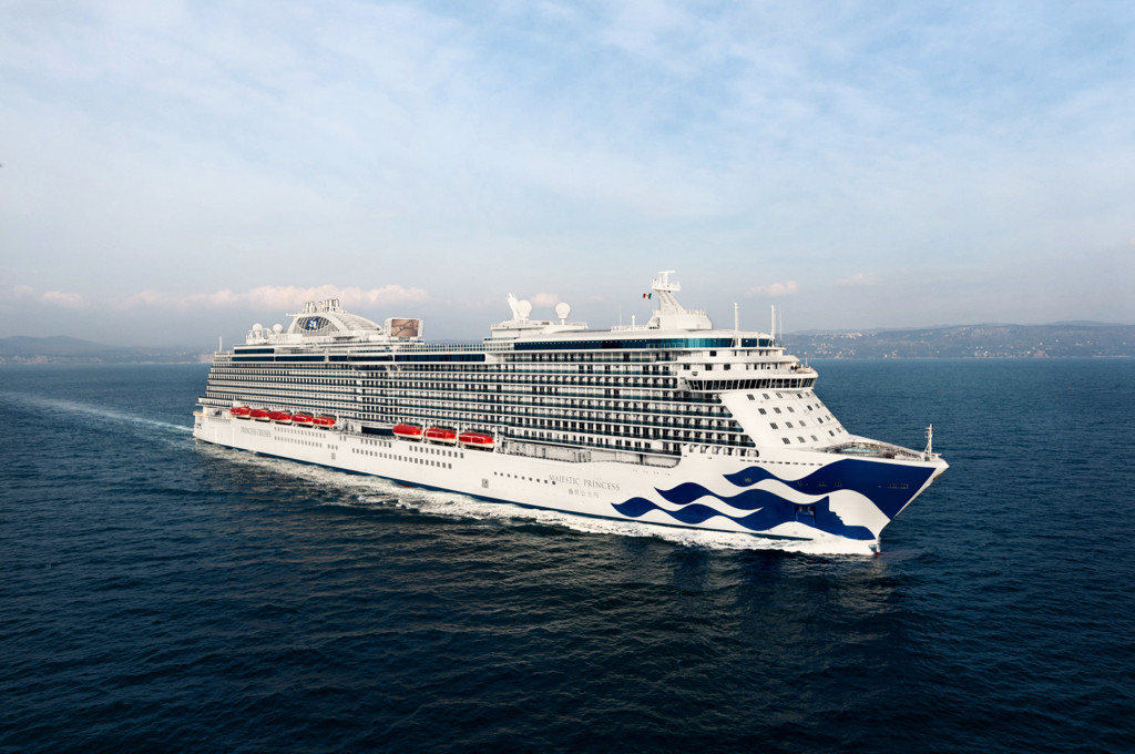 Die Majestic Princess fährt auf dem blauen Meer mit den charakteristischen Wellenmotiven der Reederei.