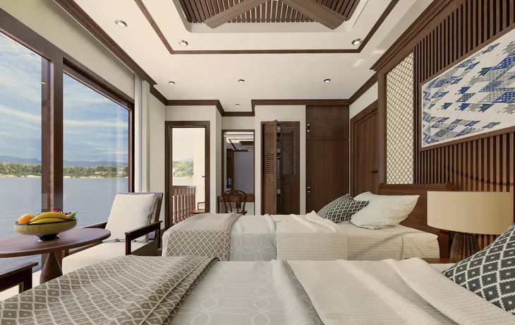 Deluxe-Kabine auf dem Oberdeck mit zwei Betten, Sitzecke am Panoramafenster und Zugang zum privaten Balkon über dem Mekong.