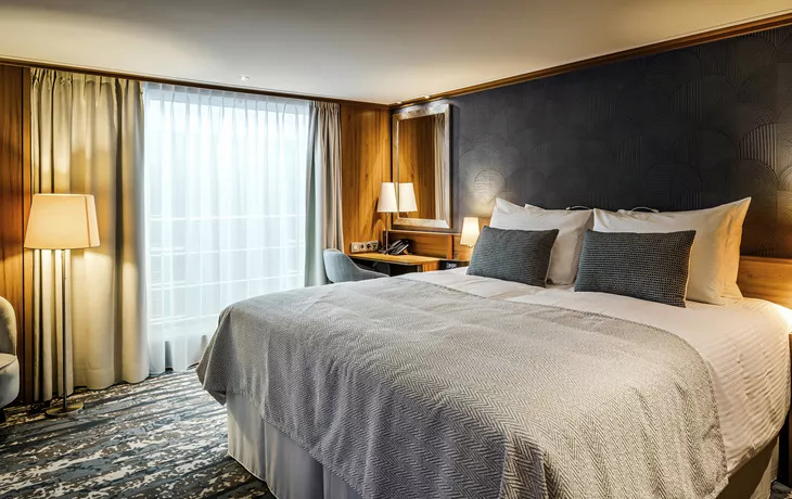 Doppelkabine auf dem Mitteldeck mit Doppelbett vor dunkler Paneelwand, Schreibtisch und französischem Balkon