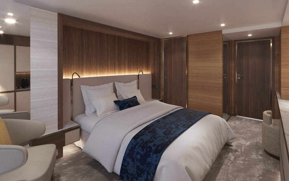 Standard-Doppelkabine auf dem Hauptdeck mit Doppelbett vor beleuchteter Holzwand, Sessel und Kleiderschrank